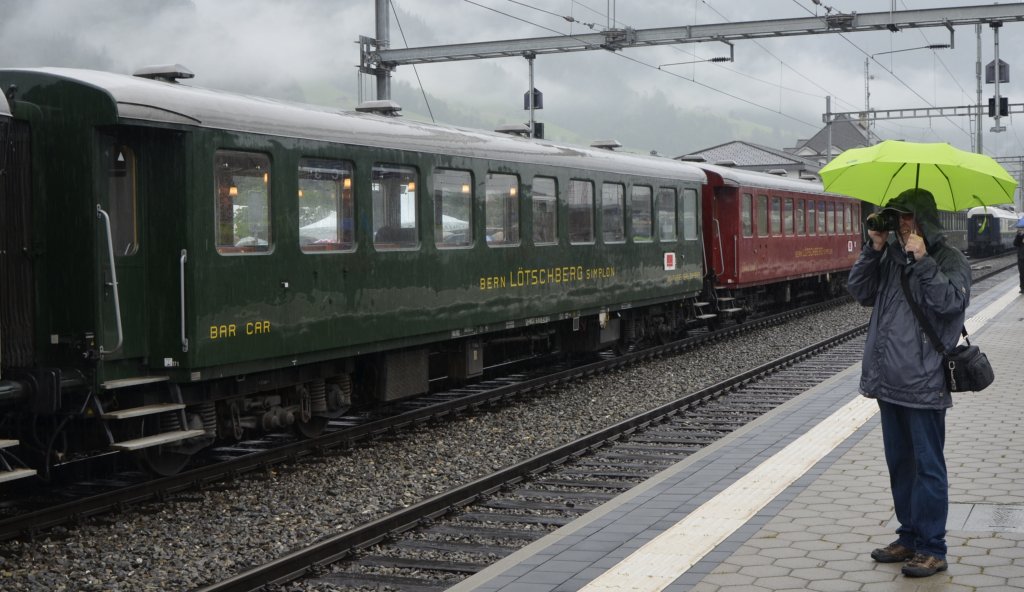 100 Jahre BLS, Jubil�umsfeier in Frutigen. Hier eine Aufnahme von Samstagvormittag. Gefragt war der  mehrarmige  Fotograf, um die Linse und sich selbst vor dem Dauerregen zu sch�tzen. Hier mein Bruder beim Fotografieren des historischen Zuges nach Kandersteg. (29.06.2013)