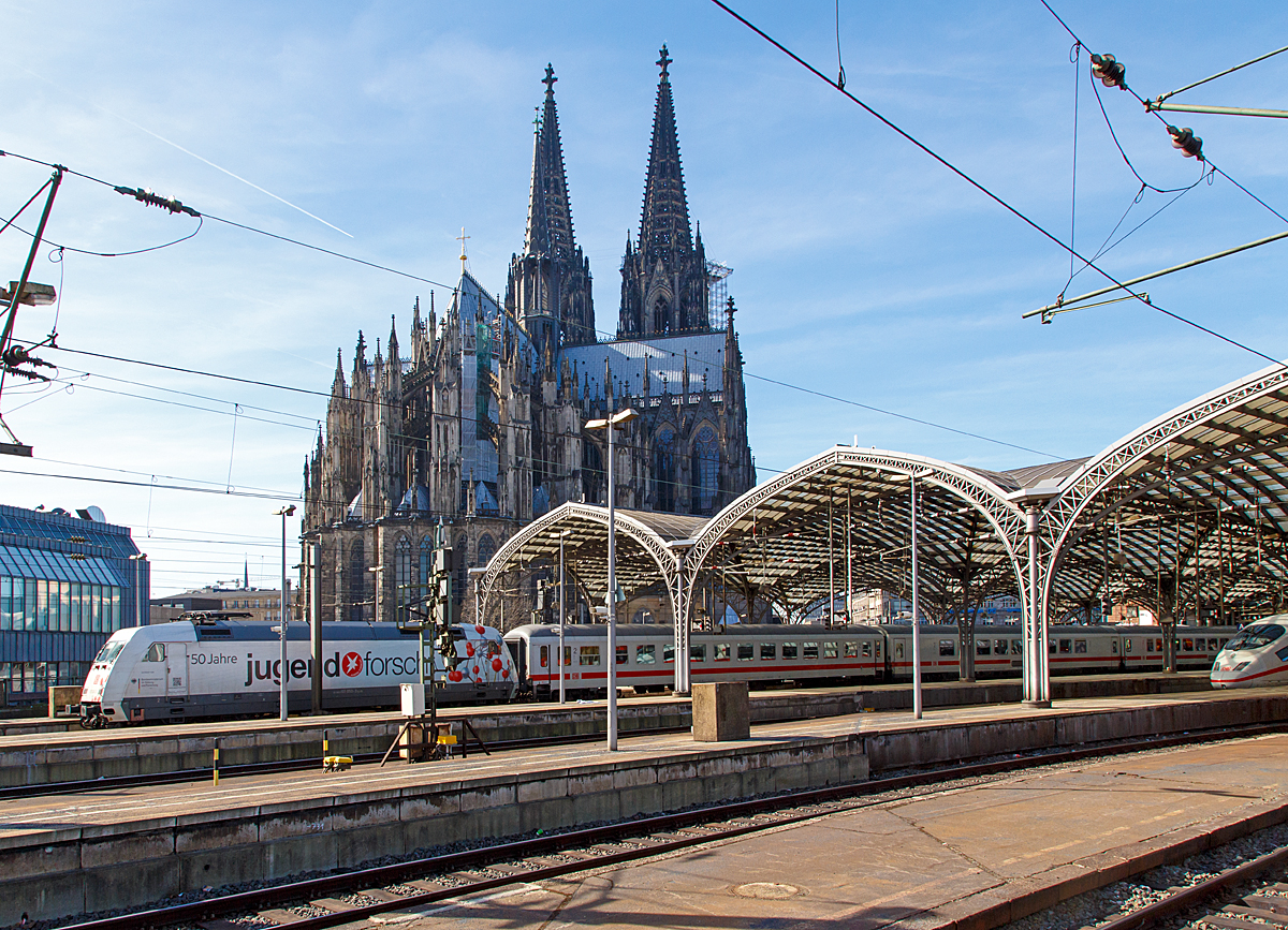 
Blick auf dem Kölner Dom vom Hauptbahnhof aus am 08.03.2015. 
Aus dem Hbf fährt gerade die 101 050-3  50 Jahre Jugend forscht  mit einem IC.