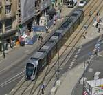 Blick vom Riesenrad auf dem ehemaligen Busbahnhof auf den Bahnhofsvorplatz der Stadt Luxemburg auf die Tram 120 welche die Hauptverkehrsachse vor dem Bahnhof überquert. Die Fahrspur am rechten Bildrand ist hauptsächlich den Stadtbussen vorenthalten. 06.2022 